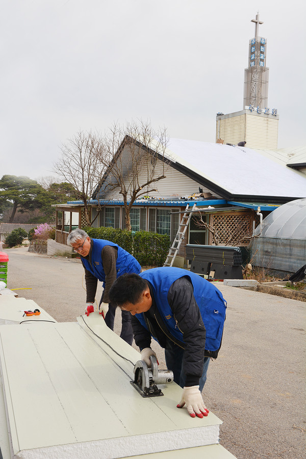 만백성건축선교단이 구슬땀을 흘리며 지붕에 올릴 자재를 손질하고 있다.