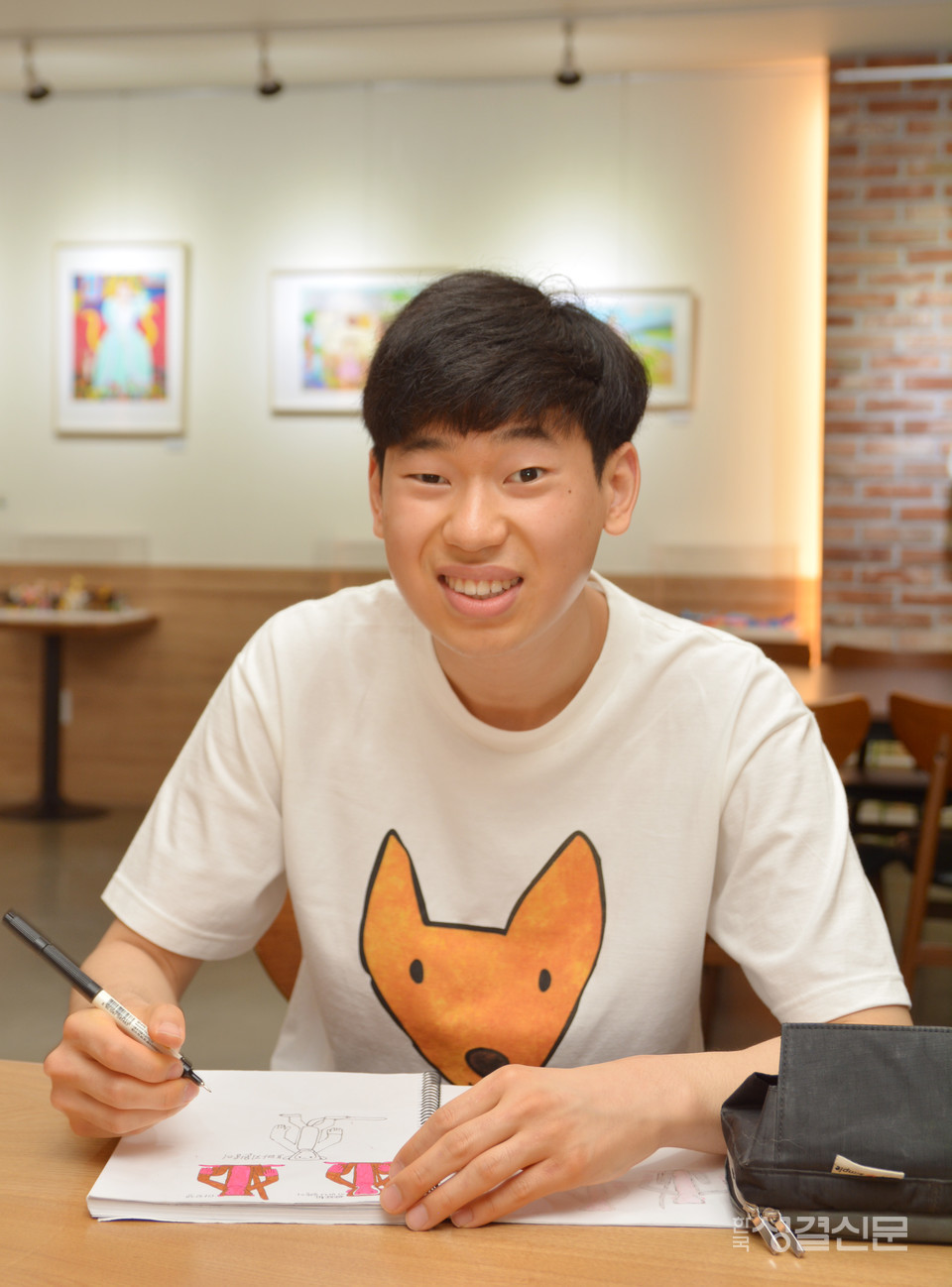                 이상욱 작가가 스케치북에 동물 그림을 스케치하는 모습.