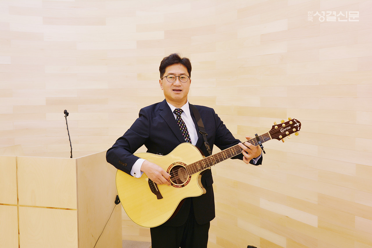 우리 교단 '시와사랑이있는교회' 박경철 목사가 주일 예배에서 기타를 치며 찬양하는 모습.