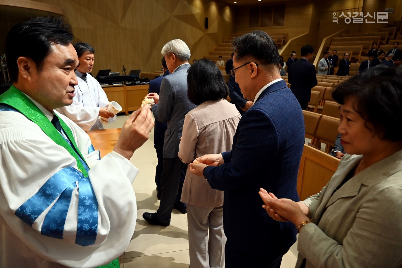 엄숙한 가운데 거행된 초대교회 성례전. 사진은 목사 부총회장 안성우 목사와 회계 문형식 장로 배종위원으로 섬기고 있는 모습.