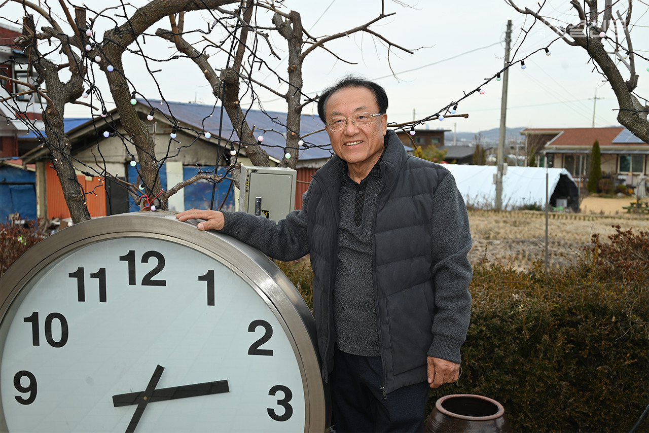 천안교회 남충희 장로가 나누고 섬기는 사역의 새 장을 열어준 '대형 시계' 앞에서 .