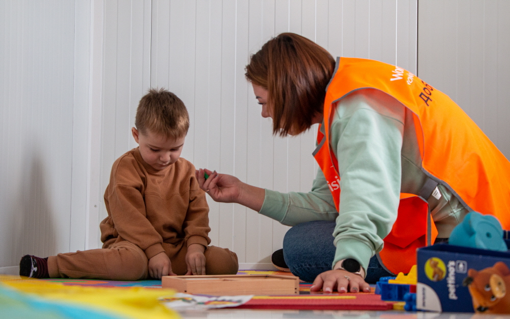 루마니아 부쿠레슈티의 월드비전 아동친화 공간에서 우크라이나월드비전 봉사자의 보호를 받고 있는 마리트(3살)의 모습. (사진=월드비전 제공)