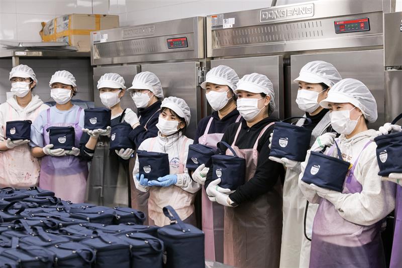 월드비전-카카오같이가치-카카오메이커스가 ‘가치상점 시즌2’ 캠페인의 일환으로 후원자 참여 도시락 제작 봉사활동을 전개했다. 사진은 월드비전 ‘사랑의도시락’을 들고 있는 봉사자들의 모습. (사진=카카오같이가치 제공)