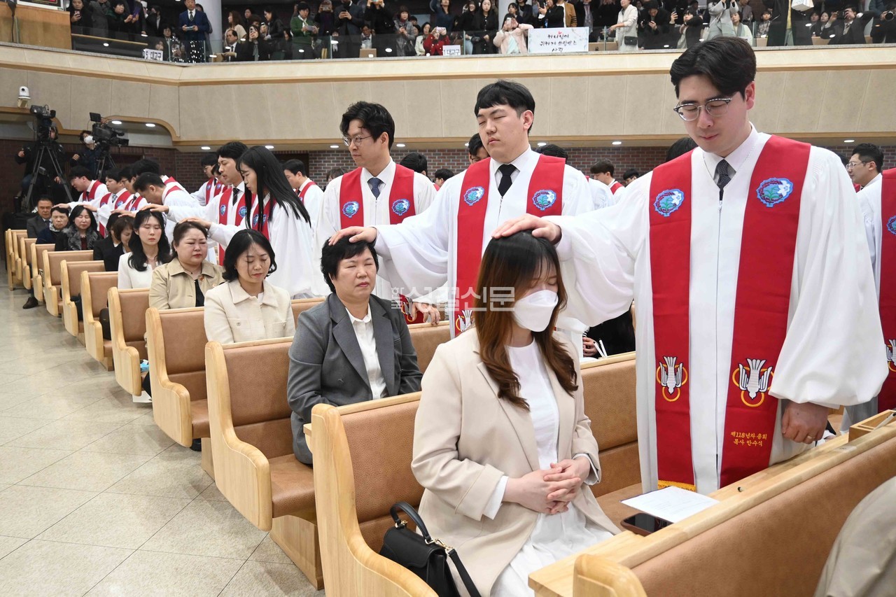 신임 목사들이 가족들에게 첫 안수기도를 하고 있는 장면.