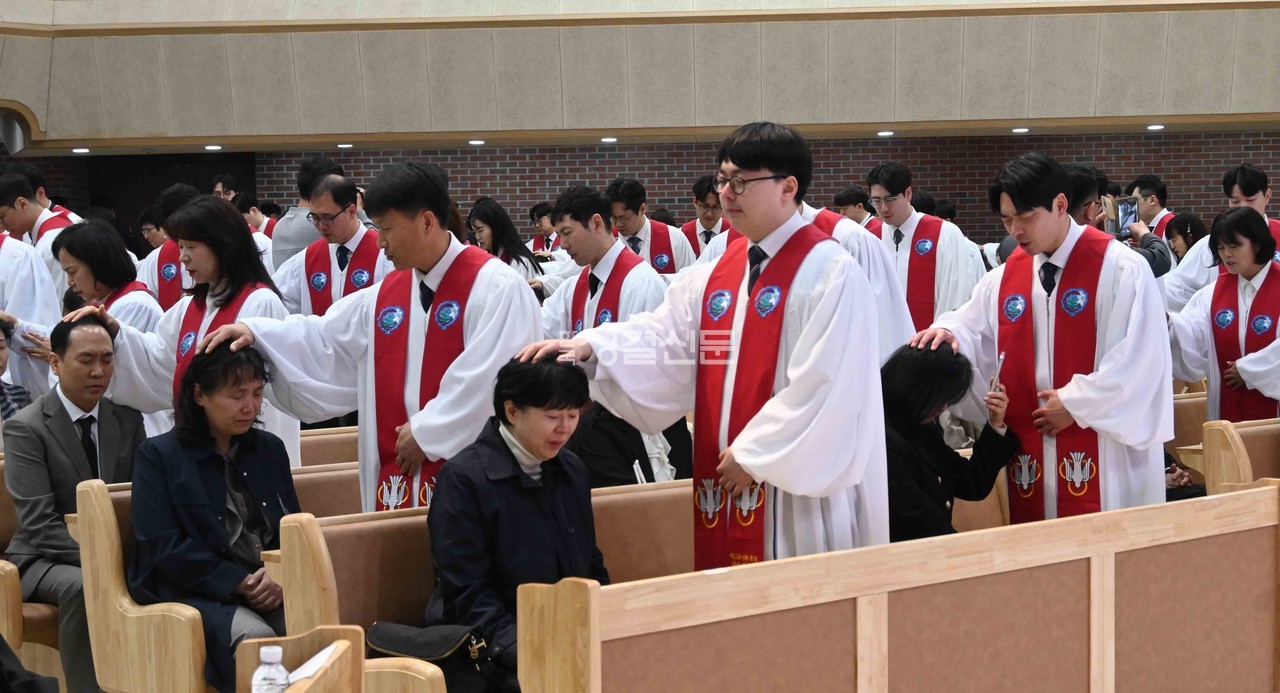 신임목사들이 가족에게 첫 안수기도를 하는 장면.