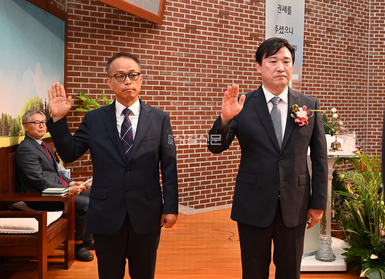 노성교회 새 담임 김훈 목사와 교회 대표 표성구 장로가 서약하고 있다.