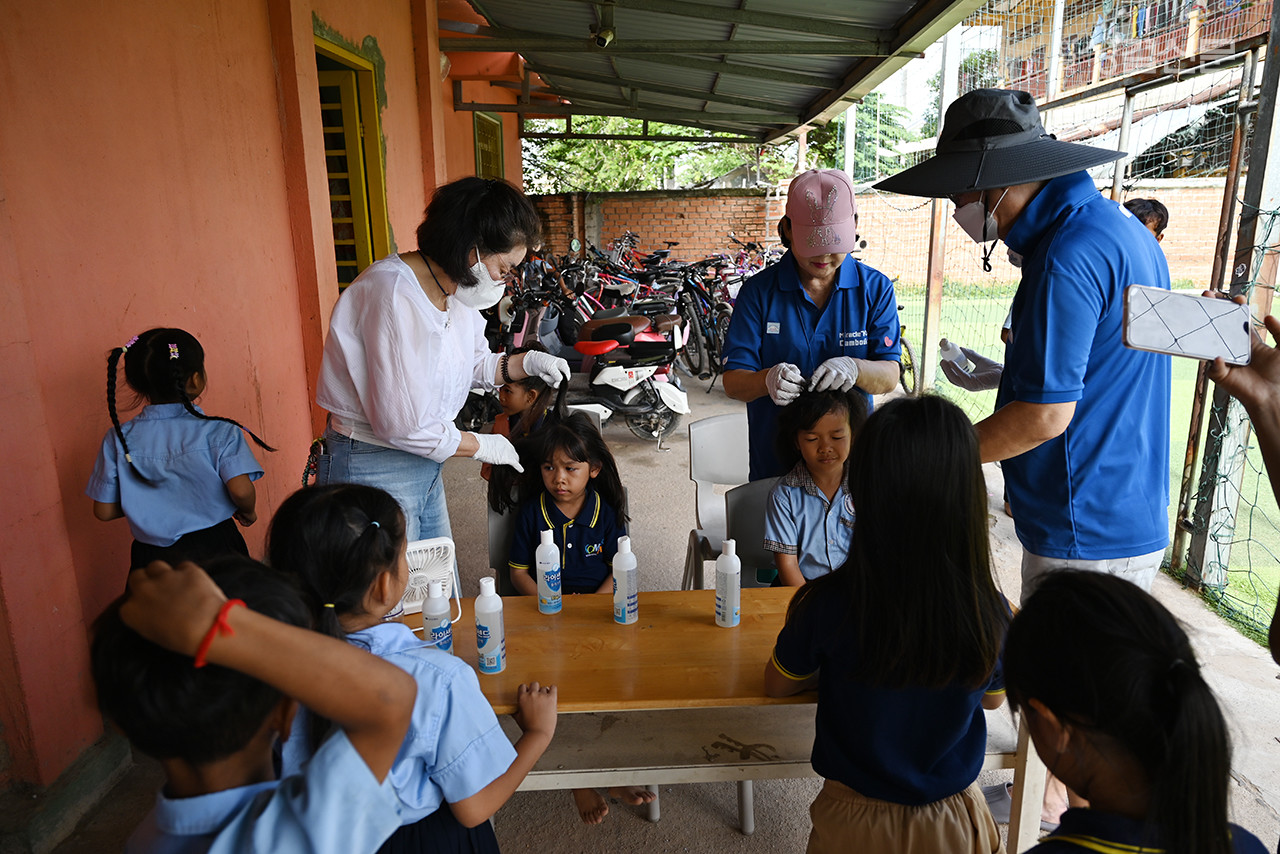 캄보디아  조이풀스쿨  어린이들에게 머릿니 약을  발라주는  사역  장면..